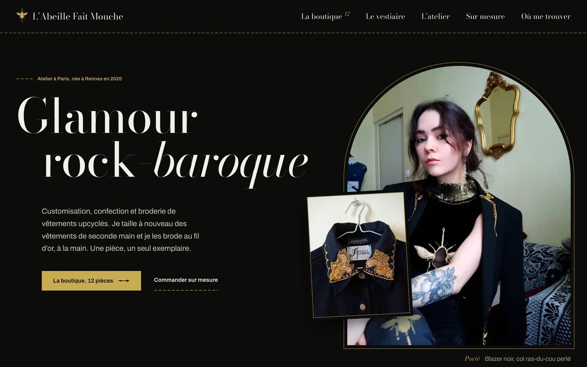 Page d’accueil de L’Abeille fait mouche : « Glamour rock-baroque » en serif clair sur fond noir, à côté d’un portrait de la créatrice dans une arche dorée et d’une veste brodée sur cintre.